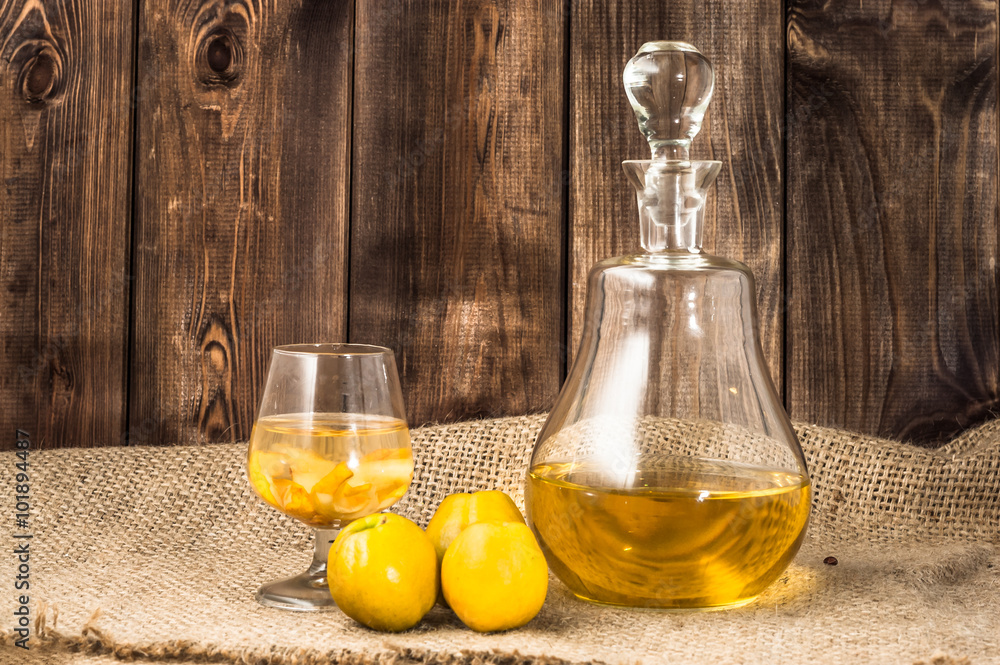 Φωτογραφία Glass of drink and carafe of alcohol tincture with quince fruits