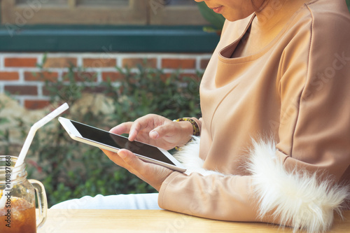 Woman using tablet computer and drinking coffee. Focus on tablet