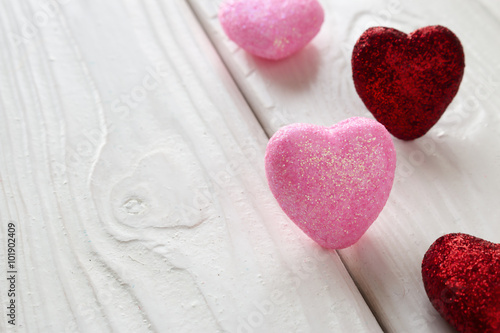pink and red hearts on a white wooden background