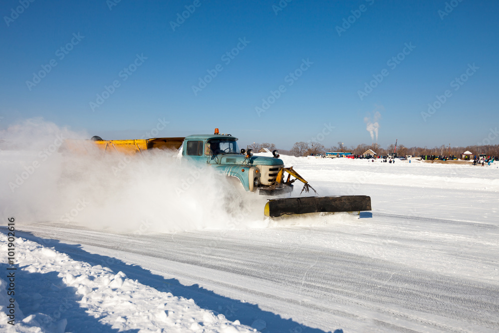 Snowplow is cleaning a road covered with ice Snowplow is cleaning a road covered with ice