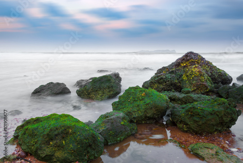 Green rock behind seascape with beautiful sky in Phuket, Thailan