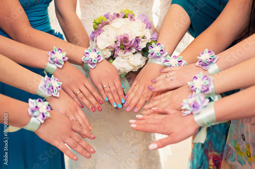 bride and her bridesmaids with bracelets on hands