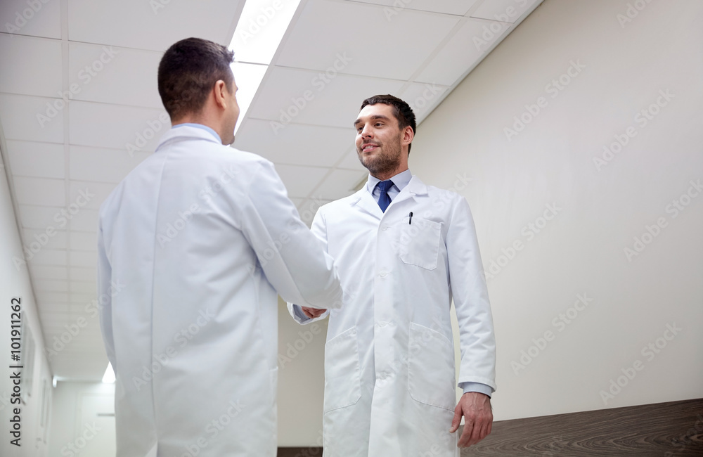 smiling doctors at hospital doing handshake smiling doctors at hospital doing handshake
