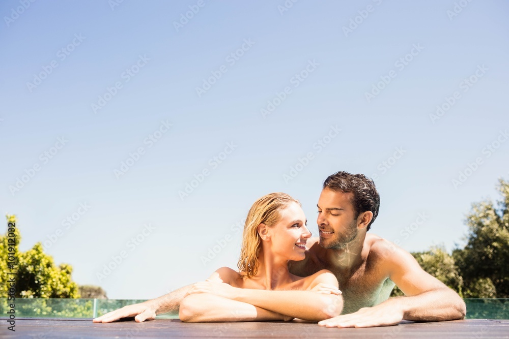 Happy couple leaning on pool edge Happy couple leaning on pool edge