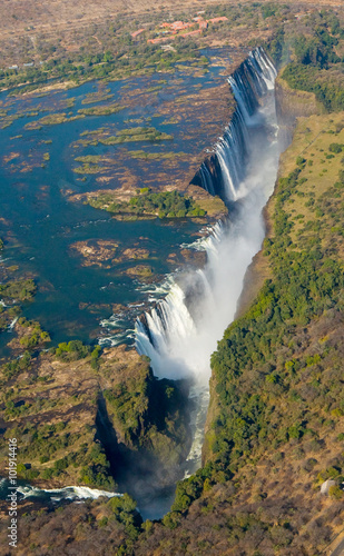 Fototapeta The Victoria falls is the largest curtain of water in the world. The falls and the surrounding area is the Mosi-oa-Tunya National Parks and World Heritage Site (helicopter view) - Zambia, Zimbabwe