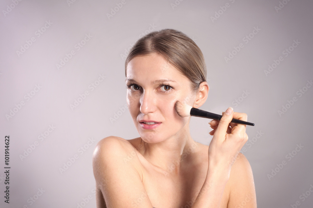 Young woman putting make-up Young woman putting make-up