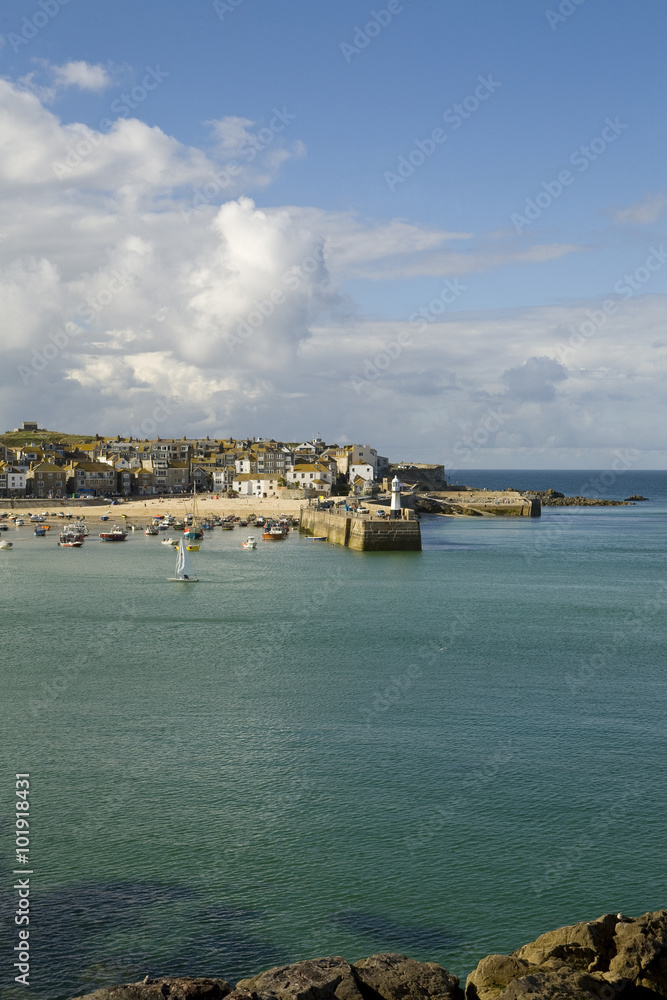St Ives Harbour. St Ives is a popular coastal town for summer vacations in England. It is an old town developed on fishing that has turned to tourism to increase it economy.
