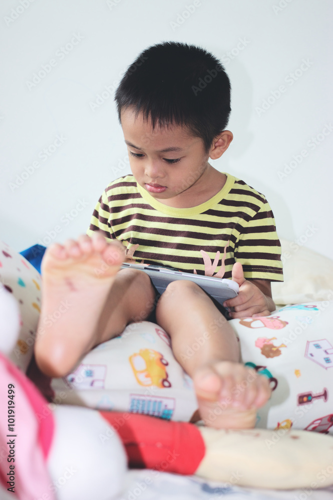 little asian kids using a digital tablet in bed little asian kids using a digital tablet in bed