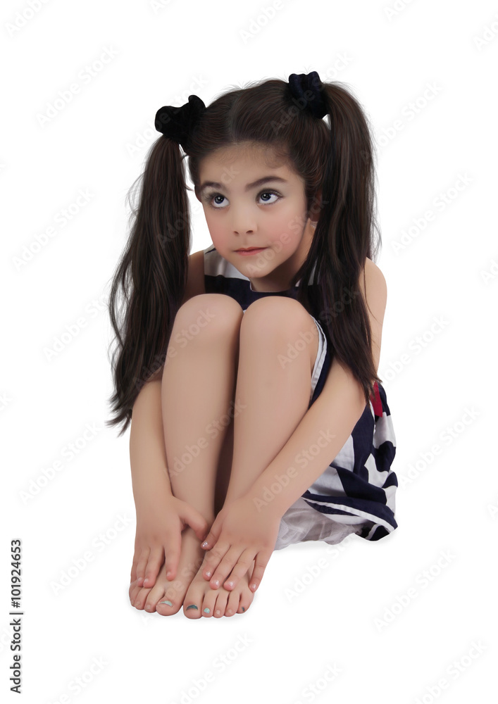 Little girl with dreamy eyes and long hair looks up sitting on white background Little girl with dreamy eyes and long hair looks up sitting on white background