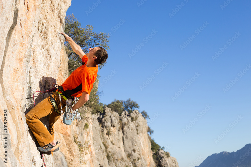 Young male climber hanging by a cliff. Young male climber hanging by a cliff.