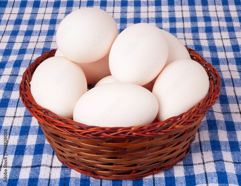 eggs in a wicker basket on blue checkered background eggs in a wicker basket on blue checkered background