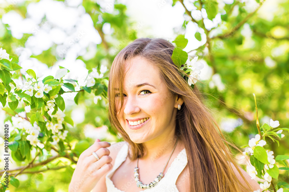 Romantic young woman in the spring garden among apple blossom, soft focus Romantic young woman in the spring garden among apple blossom, soft focus