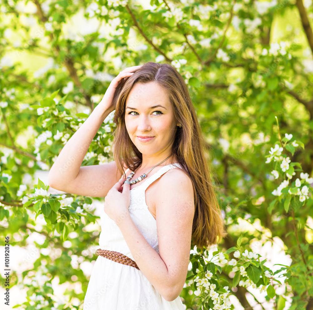 Beautiful young woman in the spring garden among apple blossom, soft focus Beautiful young woman in the spring garden among apple blossom, soft focus