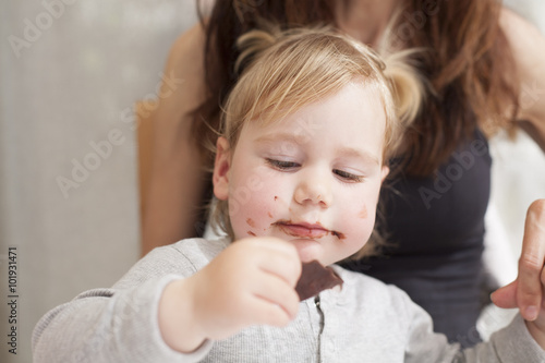 baby with mother eating chocolate