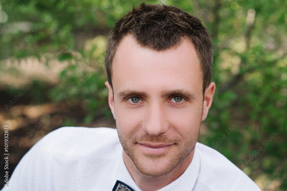 Portrait of a handsome man in a white shirt and bow tie on nature, lifestyle, concept Portrait of a handsome man in a white shirt and bow tie on nature, lifestyle, concept