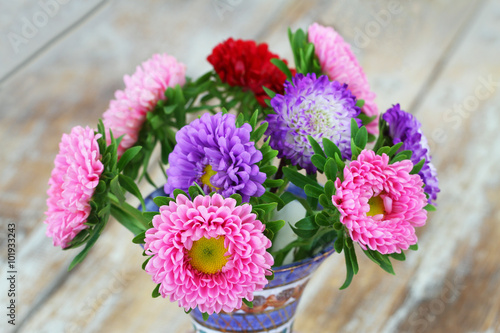 Obraz na płótnie Colorful daisy bouquet on rustic wooden surface
w salonie