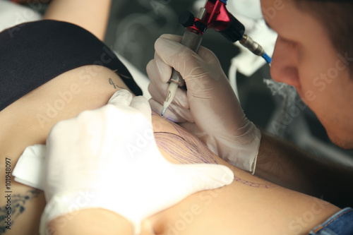 Tattooist makes tattoo, clo...