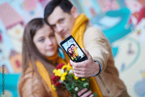 couple in love doing selfie on smartphone outdoors