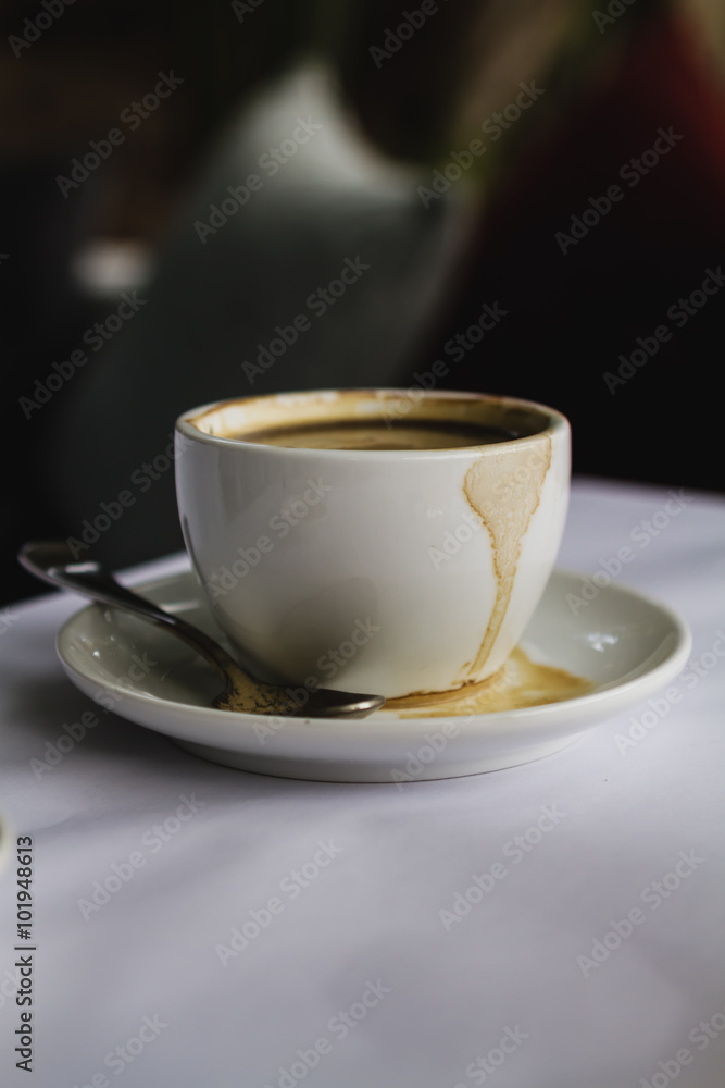 Close up of white coffee cup espresso spilt on saucer Close up of white coffee cup espresso spilt on saucer