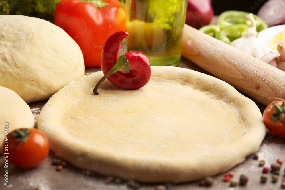 Dough basis and ingredients for pizza, on the table Dough basis and ingredients for pizza, on the table