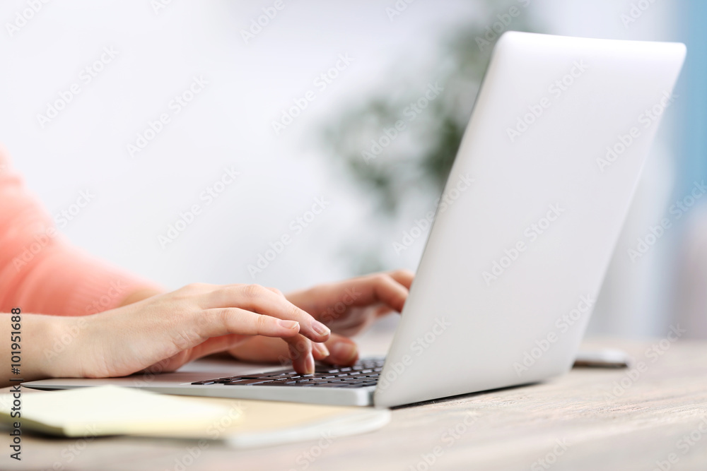 Woman sitting at the table and working with laptop Woman sitting at the table and working with laptop