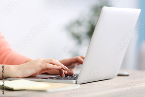 Woman sitting at the table and working with laptop