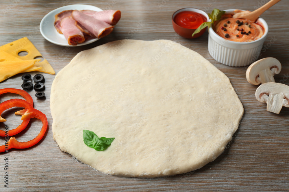 Fresh ingredients for pizza preparing on wooden table Fresh ingredients for pizza preparing on wooden table