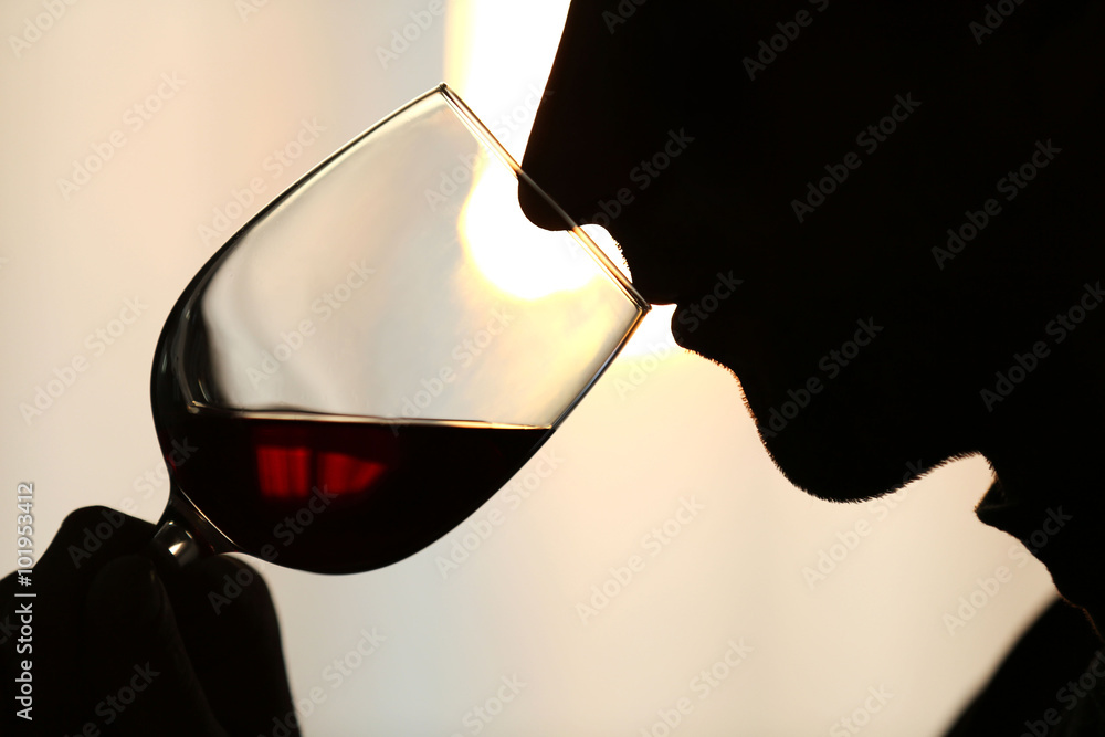 Φωτογραφία Silhouette of man sniffing red wine in a glass, close up