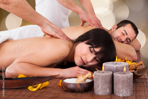 Relaxed Couple Receiving Back Massage At Spa