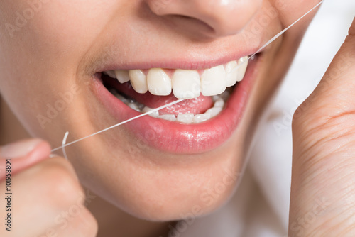 Woman Flossing Teeth At Home