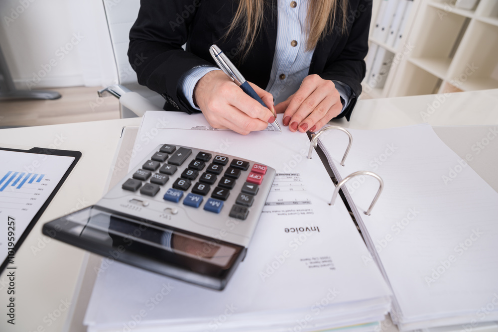 Businesswoman Calculating Invoice With Calculator Businesswoman Calculating Invoice With Calculator