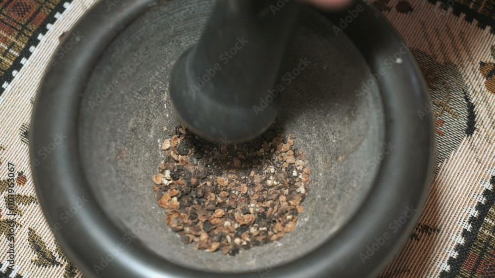 Black pepper is grinded in a stone mortar Black pepper is grinded in a stone mortar