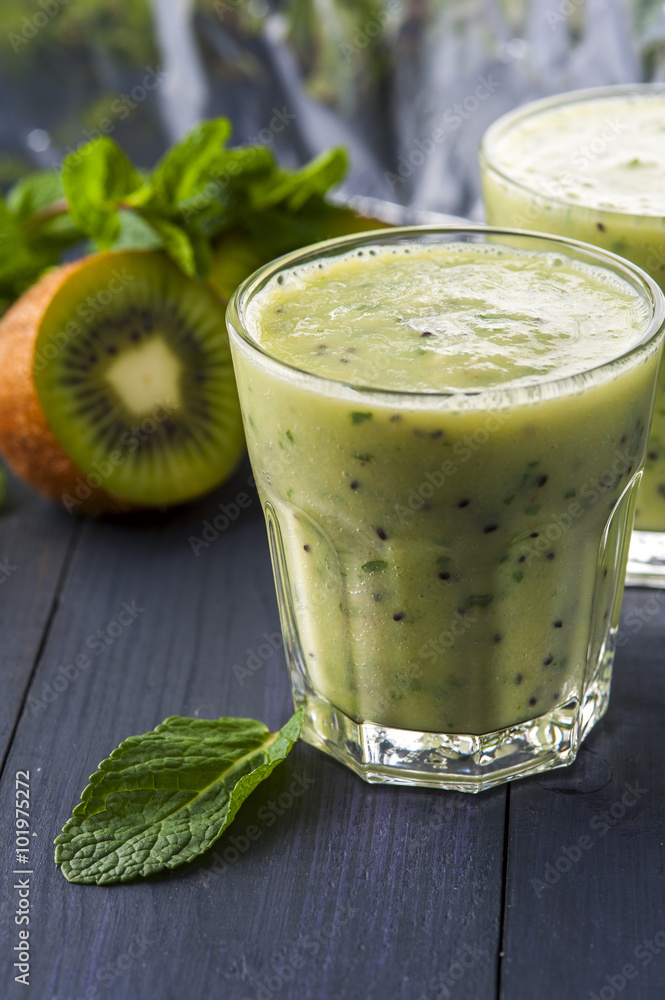 Two glasses of homemade smoothie with kiwi, banana and mint leaves . Conception of healthy food. Nonalcoholic drinks. Two glasses of homemade smoothie with kiwi, banana and mint leaves . Conception of healthy food. Nonalcoholic drinks.