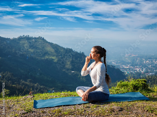 Canvas-taulu Woman practices pranayama in lotus pose outdoors