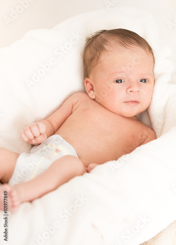 Cute newborn baby with blue eyes lying in basket