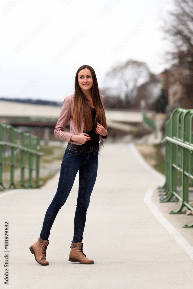 Beautiful brunette girl wearing leather jacket, blue jeans and boots Stock  Photo | Adobe Stock