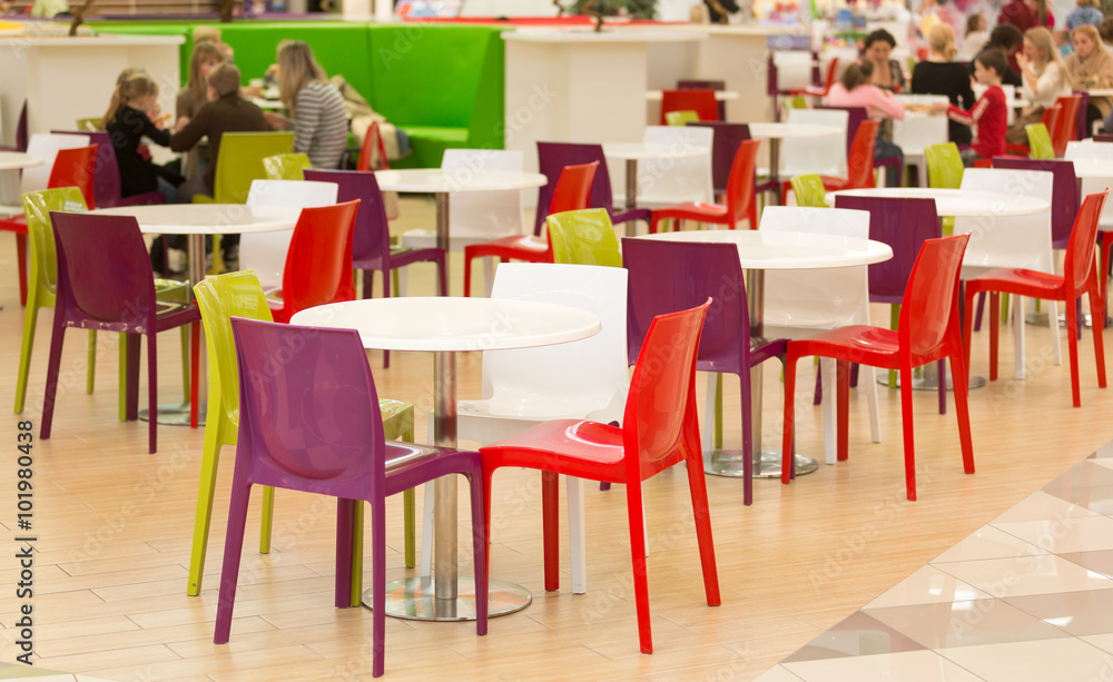 public dining area with colourul plastic chairs and tables
