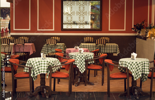 Toned image of italian restaurant interior with wooden chairs an