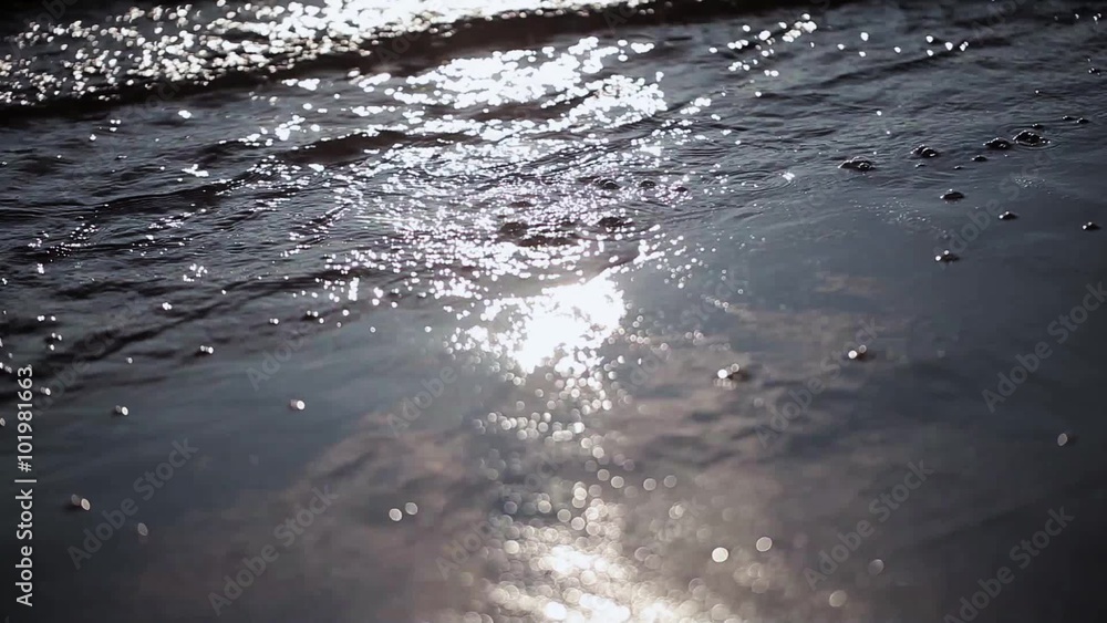 Sea waves gently wash up focus in out. Sparkling sun beams. Summer. Close up Sea waves gently wash up focus in out. Sparkling sun beams. Summer. Close up
