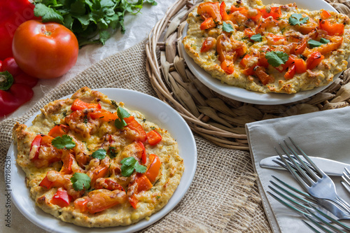 Pizza on the basis of chicken with tomatoes, peppers and cheese