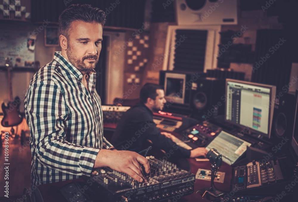 Φωτογραφία Sound engineer and producer working together with professional audio equipment in the boutique recording studio