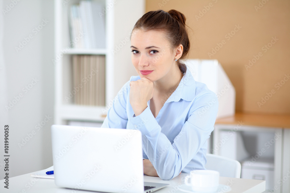 Young business woman working on laptop in office. Successful business concept. Young business woman working on laptop in office. Successful business concept.