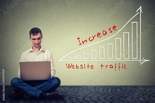 man using laptop working on a plan to increase website traffic. Technology marketing concept photo