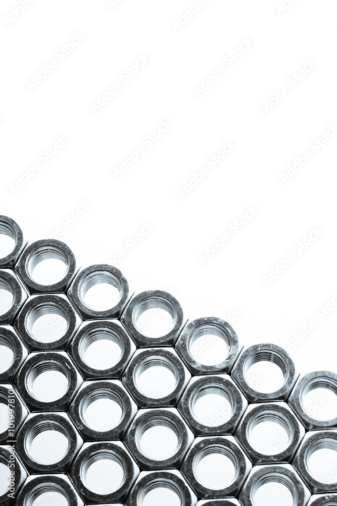 Nut screws tightly stacked next to each other on a flat surface. Nut background isolated on white. Nut screws tightly stacked next to each other on a flat surface. Nut background isolated on white.