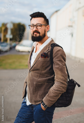 young guy with a beard and mustache with glasses in a suit posing on the street in the sunlight, outdoor portrait, close up, beard, handsome man © armada1985