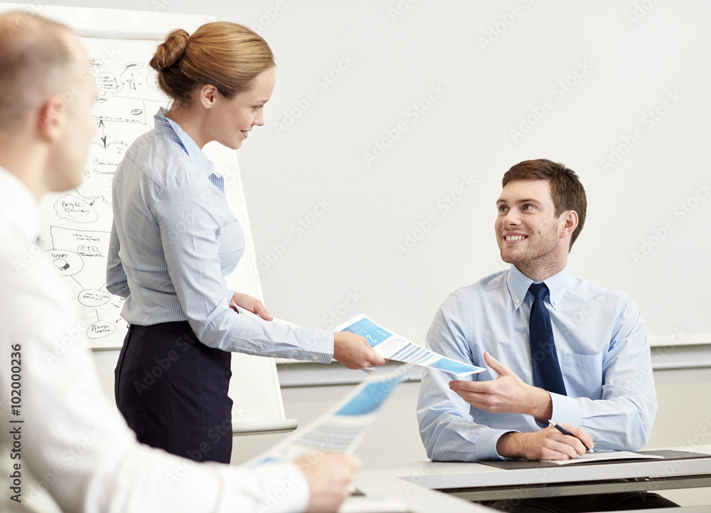 smiling woman giving papers to man in office smiling woman giving papers to man in office