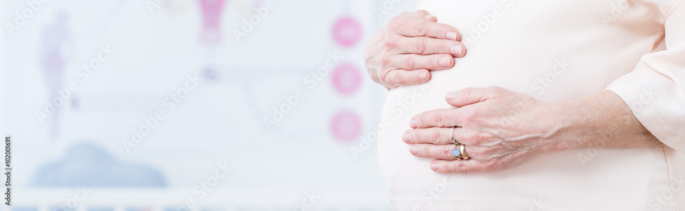 Mature pregnant touching tummy
