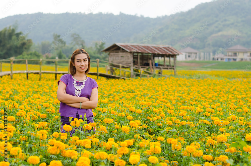 Fototapeta premium Thai women in traditional costume at a marigold garden.
