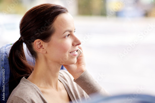 happy woman in travel bus calling on smartphone