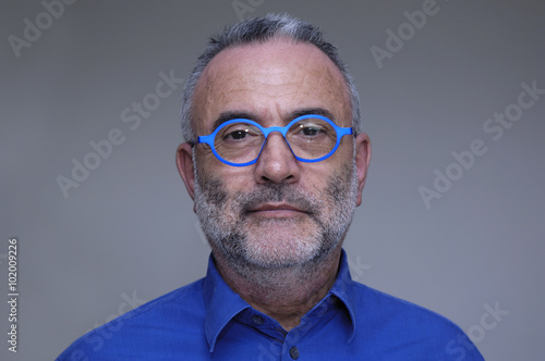 middle-aged man with blue shirt and glasses photo